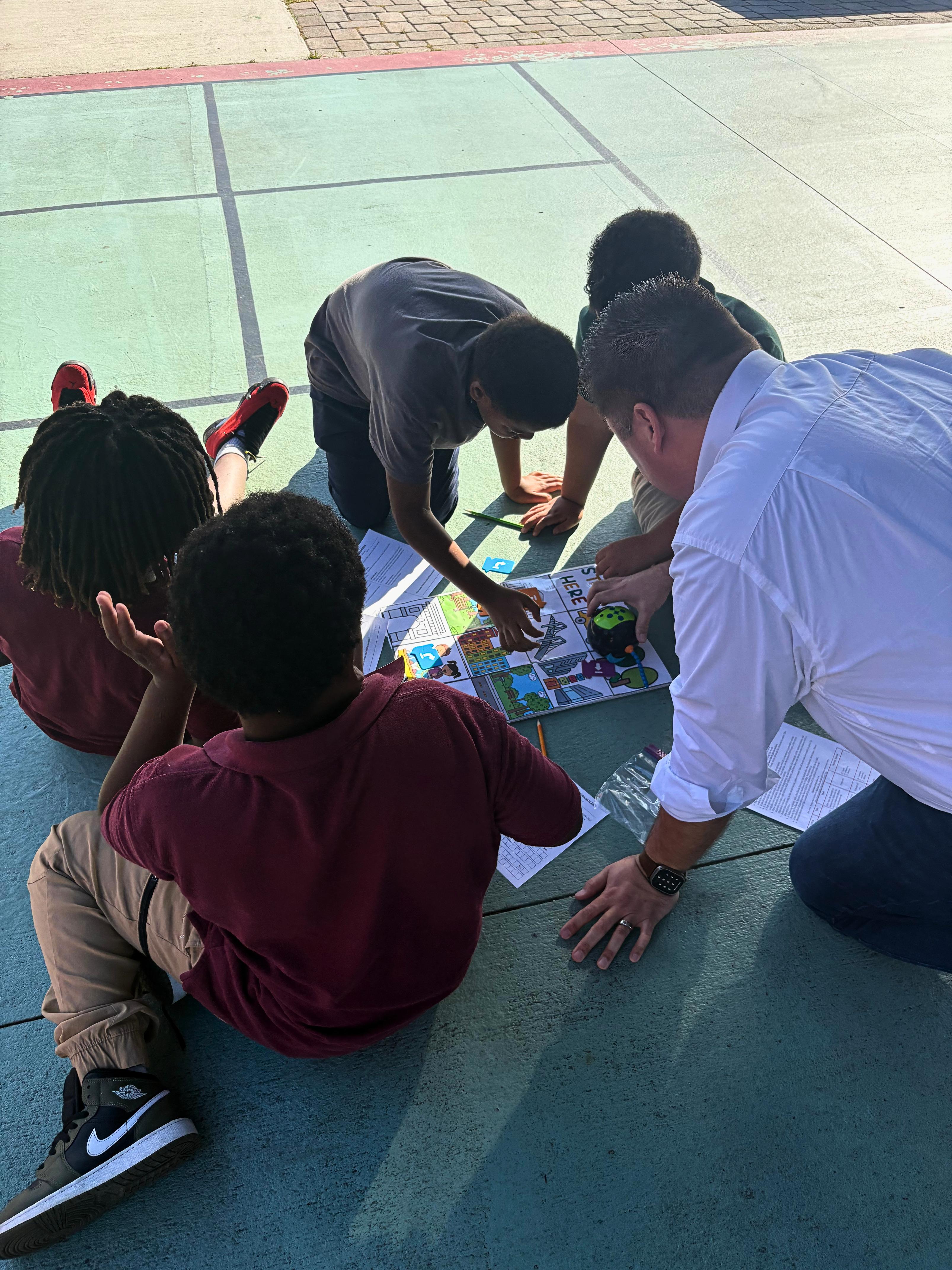 Students learning with a programmable robot on an outdoor court